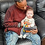 Dante joined the competition — help win amazing prizes! adult, baby, black_leather_couch, blue_jeans, casual_clothing, colorful_toy, cozy, distressed_jeans, family, holding, home, indoor, intimate_moment, looking_down, maroon_jacket, parent_and_child, sitting, smartphone, toy, white_socks