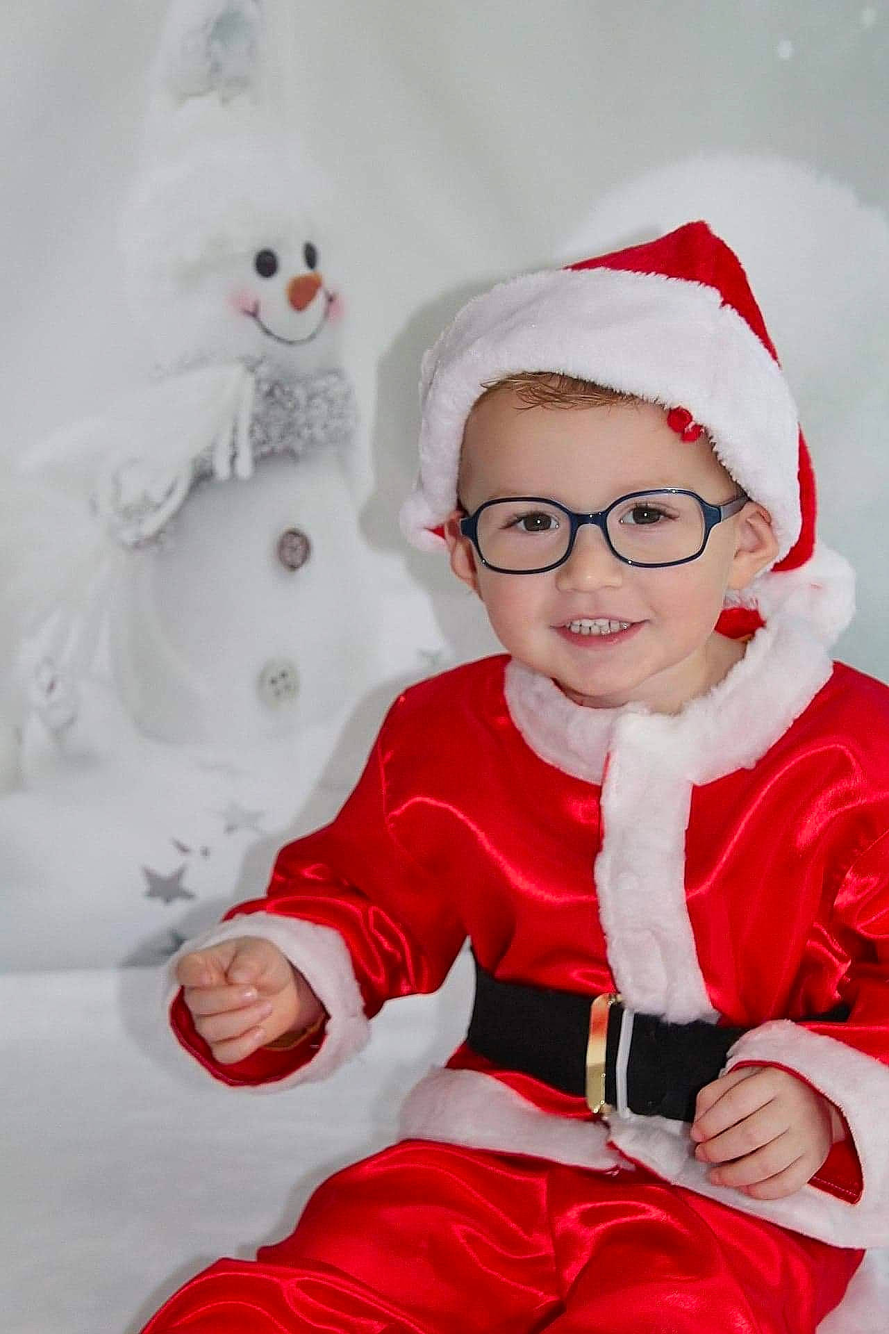 Ylenzo participe au concours pour gagner de l'argent avec cette photo : baby, carmine, christmas, christmas_eve, costume, costume_accessory, costume_hat, facial_expression, fictional_character, fur, happy, holiday, joy, lap, laugh, person, pleased, red, sitting, snowman