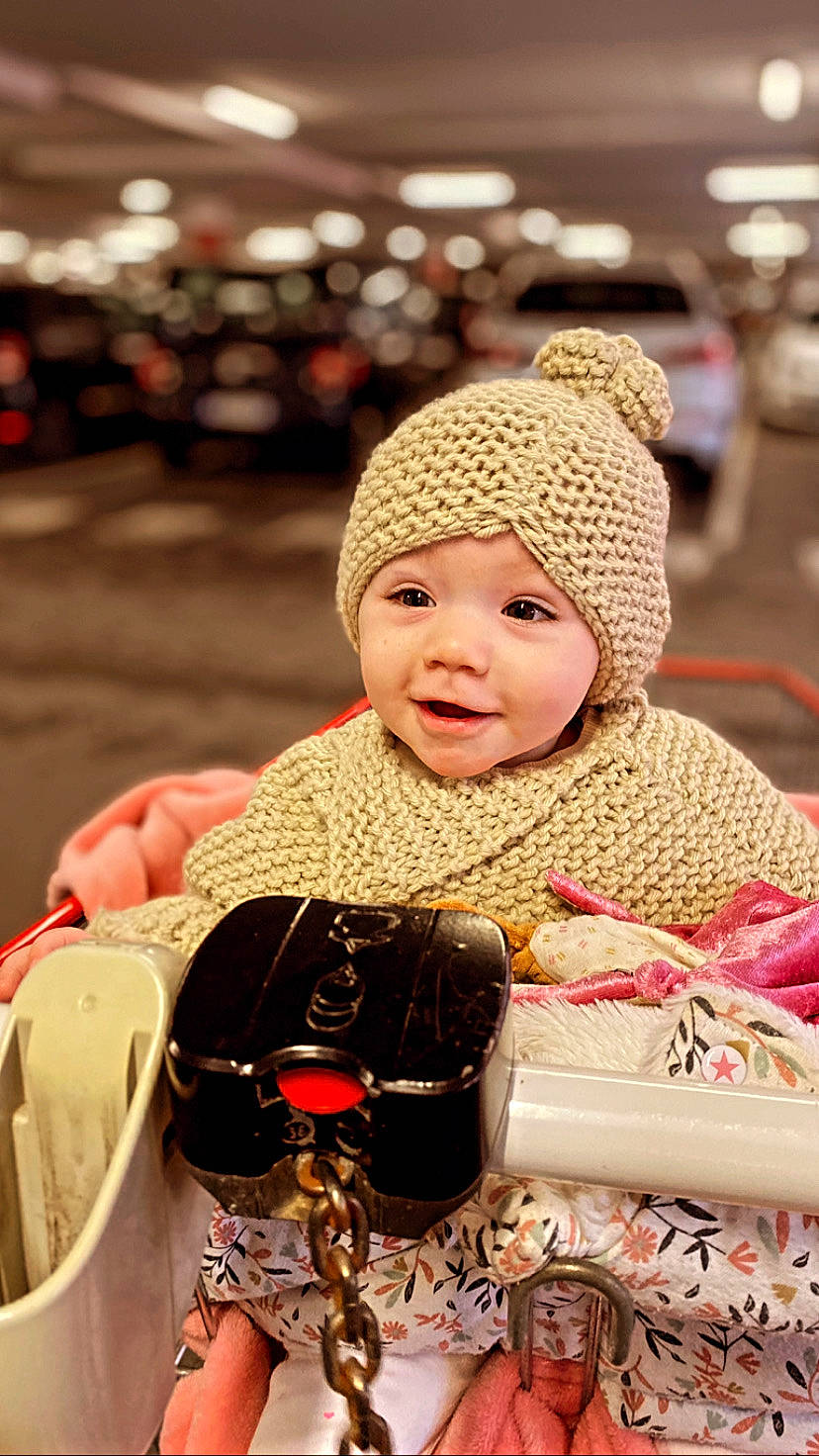 Anghjula-maria a rejoint le concours — aidez-le/la à gagner de superbes lots ! baby, cap, child, event, facial_expression, fashion, fashion_accessory, fun, happy, headgear, headwear, helmet, knit_cap, leisure, person, sitting, skin, smile, textile, toddler