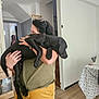 Aïko participe au concours pour gagner de l'argent avec cette photo : affection, animal, black_dog, casual_clothing, dog, doorway, furniture, glasses, hand, home, hugging, indoor, living_room, person, pet, relaxed, stairs, table, tablecloth, wooden_floor