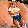 baby, infant, girl, smiling, headband, pink_socks, denim_shorts, cushion, knit, comfortable, happy, cute, clothing, indoor, person, child, portrait, resting, soft, expression