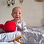 baby, child, smiling, blue_eyes, plush_toy, bed, blanket, dreamcatcher, wall_decor, mobile, stars, clouds, pajamas, indoor, cute, happy, infant, soft_toys, portrait, cozy