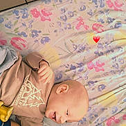 Léon participe au concours pour gagner de l'argent avec cette photo : affection, baby, blanket, casual_clothing, cozy, face, family, floral_pattern, glasses, happy, heart_emoji, indoor, interaction, joy, love, lying_down, portrait, smile, tile_floor, woman