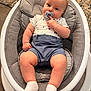 baby, infant, bouncer, pacifier, onesie, shorts, socks, seat, cushion, mesh, rug, wooden_floor, chubby_legs, hand, face, eyes, hair, cozy, portrait, home_interior