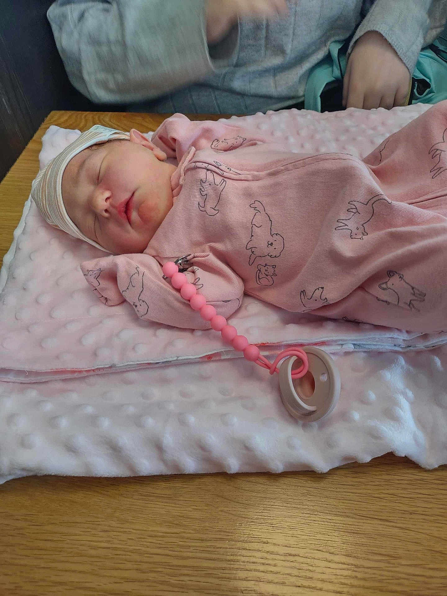 Raelynn is registered to the contest to win money with this photo: newborn, baby, sleeping, pink_outfit, animal_prints, blanket, pacifier, clip, hand, wooden_table, soft_texture, infant, child, person, rest, cute, indoors, peaceful, cozy, clothing