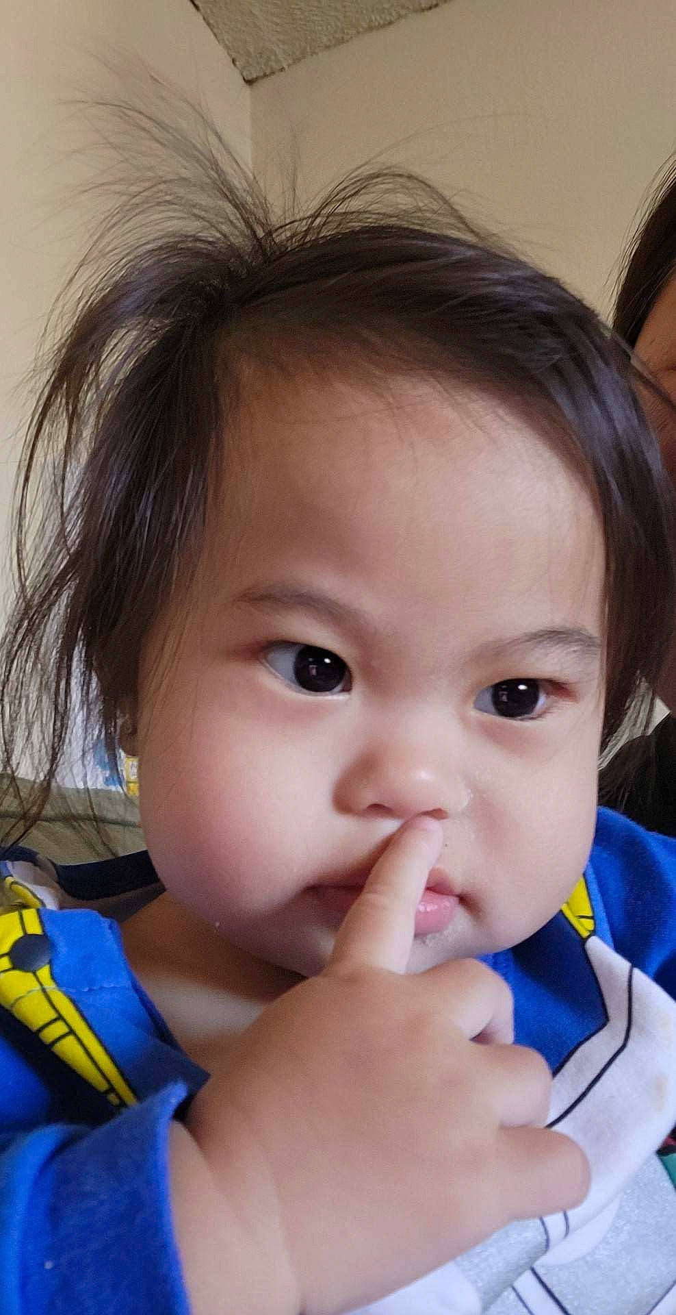 Flora is registered to the contest to win money with this photo: baby_toddler_clothing, cheek, chin, ear, eye, eyebrow, eyelash, face, facial_expression, gesture, hair, hand, happy, head, iris, lip, mouth, neck, nose, person