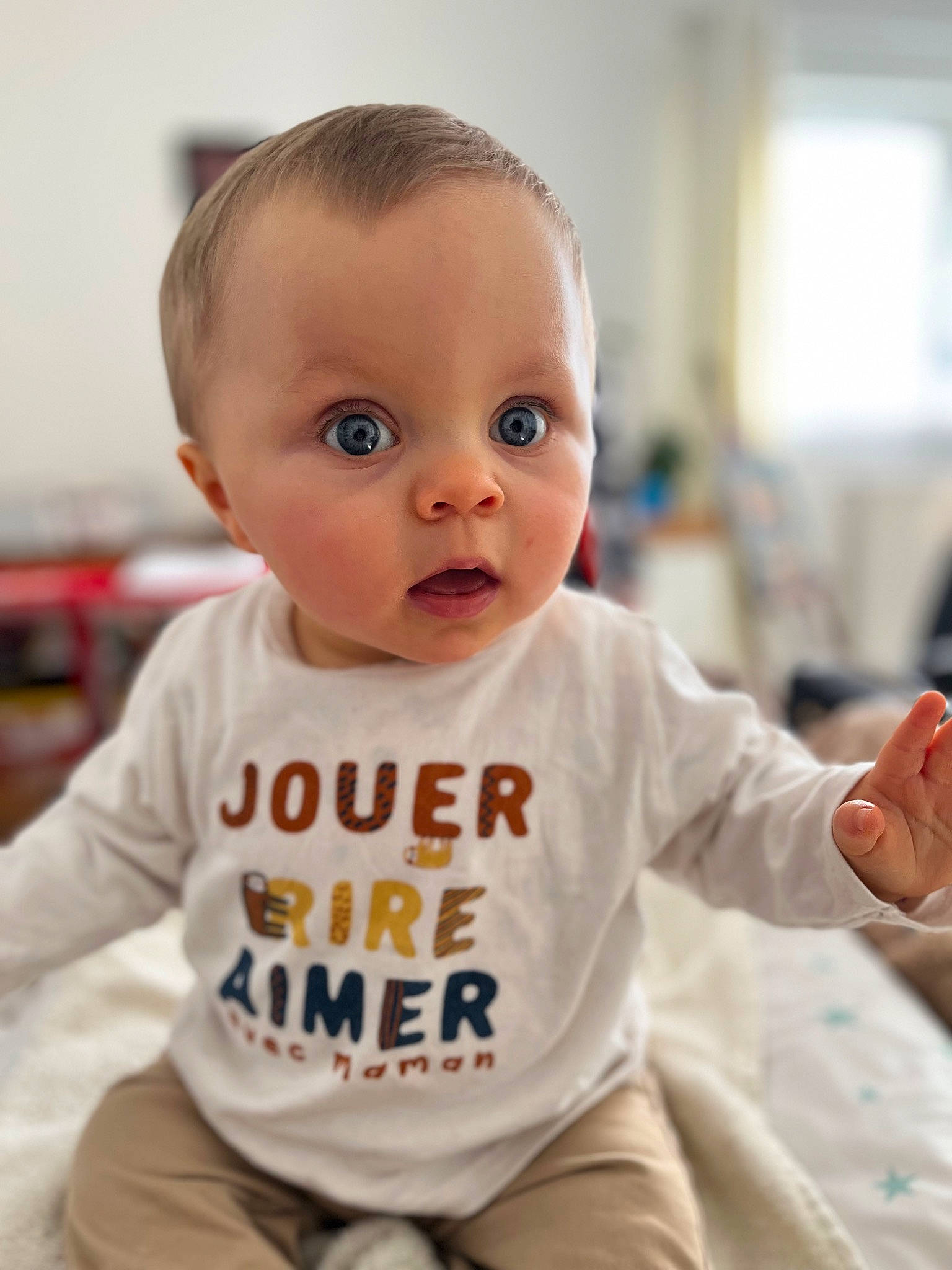 Maxime participe au concours pour gagner de l'argent avec cette photo : baby, baby_toddler_clothing, cheek, child, chin, comfort, face, flooring, fun, gesture, hairstyle, happy, person, portrait_photography, room, sitting, skin, sleeve, standing, surprise