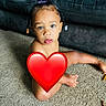 child, toddler, portrait, sitting, carpet, couch, indoor, home, face, eyes, braids, hair_accessories, heart_sticker, privacy_cover, bare_shoulders, floor, furniture, photography, centered, colorful