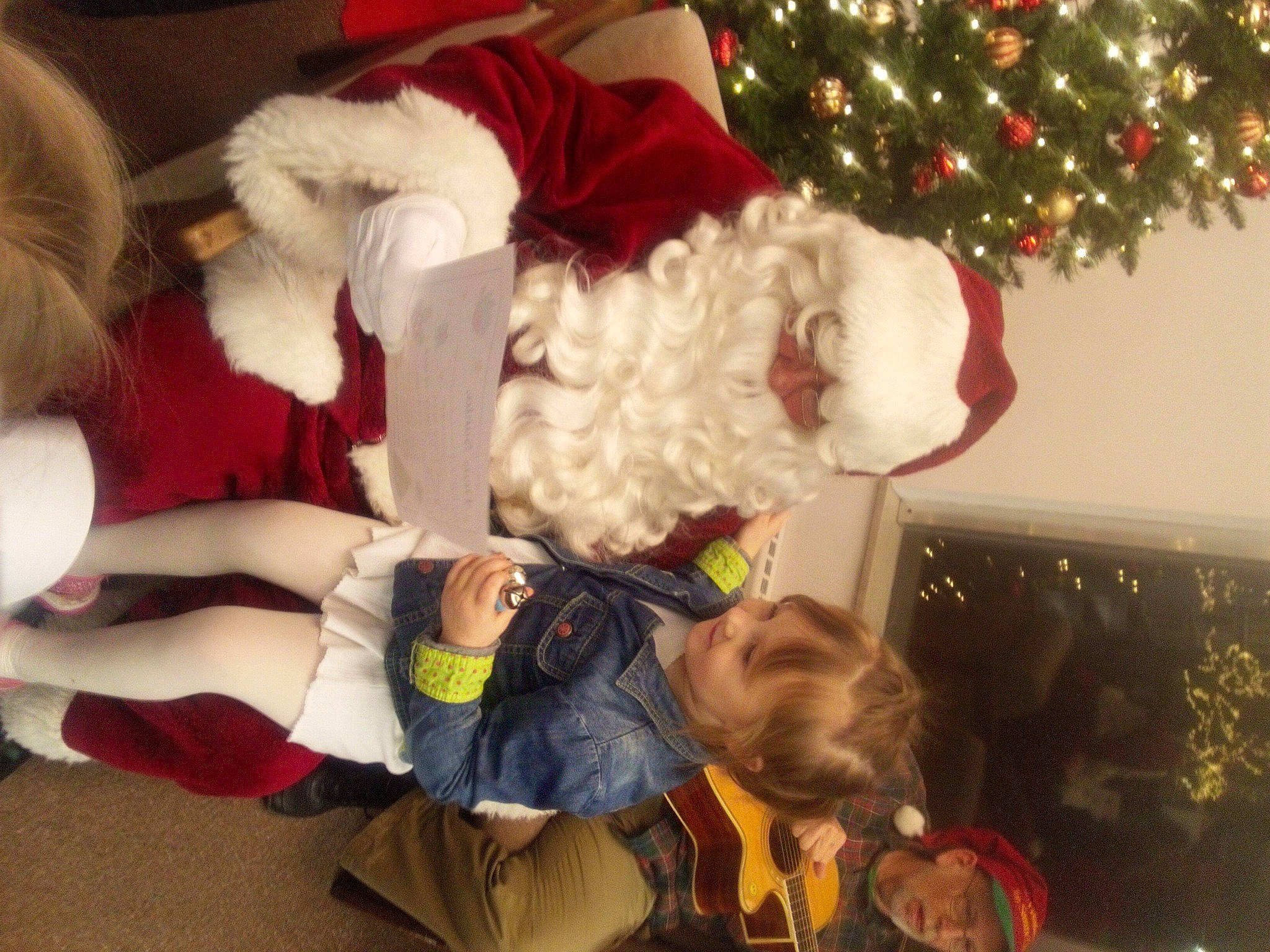 Dallas is registered to the contest to win money with this photo: baby, child, christmas, christmas_decoration, christmas_eve, christmas_ornament, christmas_tree, conifer, event, fictional_character, fun, fur, happy, hat, headwear, holiday, lap, person, plant, santa_claus