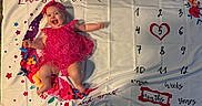 Sabrina is registered to the contest to win money with this photo: baby, celebration, child, colorful, cute, fabric, floral_pattern, happy, headband, heart, indoor, infant, lying_down, milestone_blanket, months, numbers, pink_clothing, portrait, smiling, stars