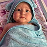 baby, child, towel, blue_towel, hooded_towel, face, eyes, blanket, unicorn, cute, chubby_cheeks, infant, portrait, indoor, bed, soft_texture, pink_background, purple_wall, bathtub_time, cozy