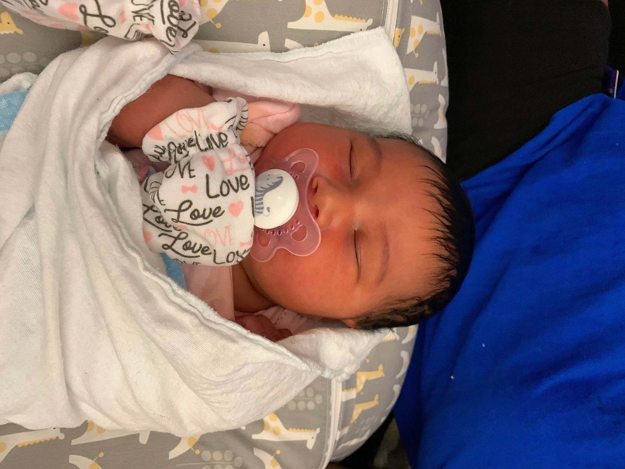 Shyanna is registered to the contest to win money with this photo: baby, baby_products, baby_toddler_clothing, bedtime, cheek, child, comfort, elbow, eye, hand, hat, headgear, human_body, mouth, nap, pattern, person, skin, sleeve, t_shirt