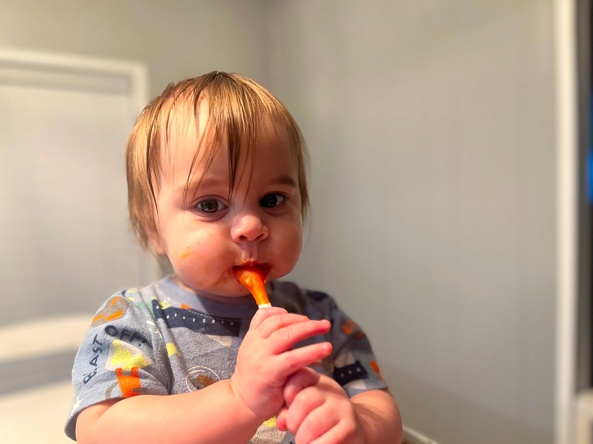 Ezra is registered to the contest to win money with this photo: baby, baby_food, biting, chair, cheek, child, eating, eyelash, food_craving, fun, lip, mouth, nose, person, play, room, sitting, standing, sweetness, thumb