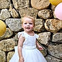 toddler, child, white_dress, balloons, stone_wall, smiling, outdoor, happy, portrait, cute, celebration, party, young_child, person, fashion, dress, event, colorful, fun, joyful