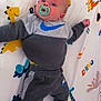 Noah is registered to the contest to win money with this photo: baby, infant, pacifier, clothing, nike, blanket, dinosaur, pattern, child, cute, lying_down, socks, colorful, playful, indoor, portrait, young, soft_lighting, cozy, happy