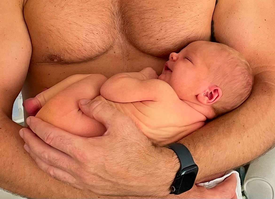 Ozzi is registered to the contest to win money with this photo: baby, newborn, infant, person, arms, hands, skin, watch, smartwatch, smile, sleeping, closeup, human, naked, chest, torso, wrinkles, love, care, protection
