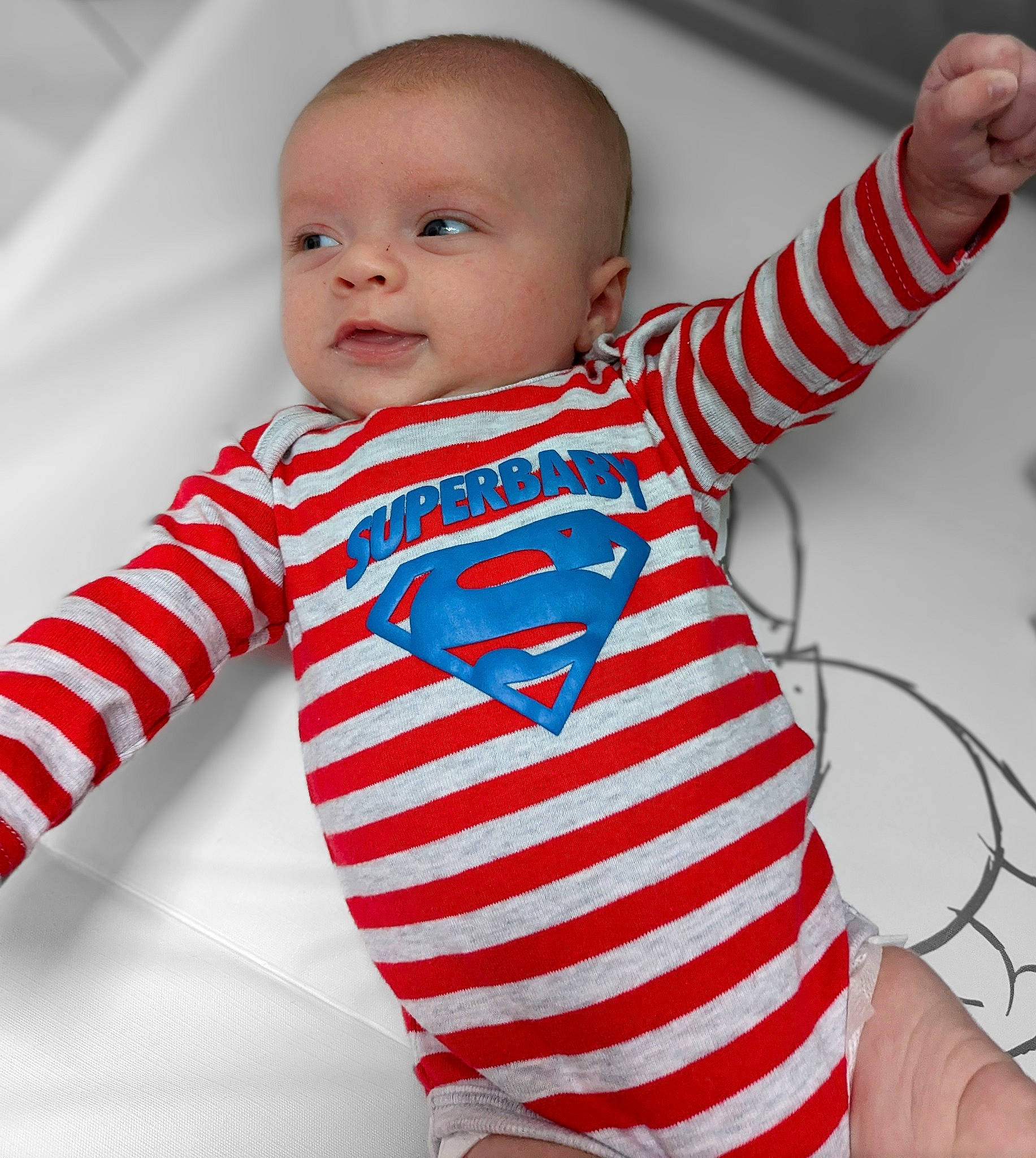 Léandro a rejoint le concours — aidez-le/la à gagner de superbes lots ! baby, baby_toddler_clothing, cheek, eye, face, facial_expression, finger, gesture, happy, head, joint, neck, outerwear, person, product, shoulder, sleeve, standing, t_shirt, textile