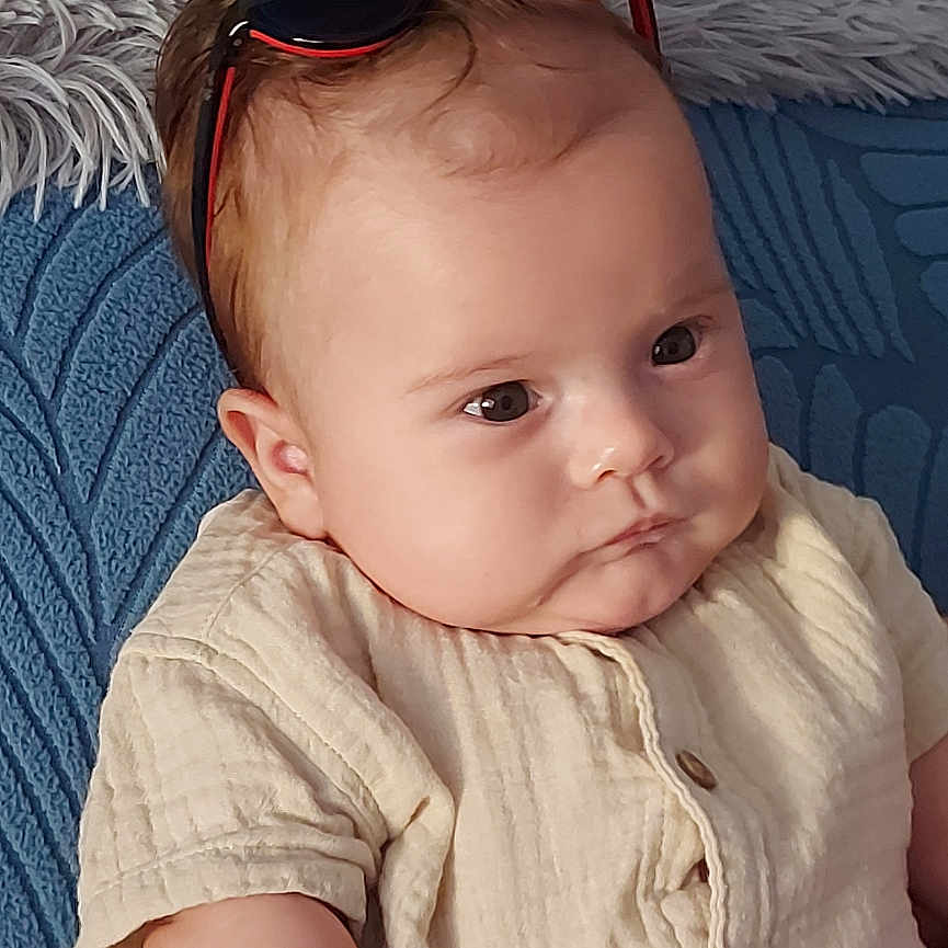 Nolan participe au concours pour gagner de l'argent avec cette photo : accessories, baby, bodypart, couch, cushion, face, finger, furniture, hand, happy, head, homedecor, jewelry, linen, person, photography, portrait, sitting, smile, sunglasses