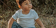 Giovanni joined the competition — help win amazing prizes! child, toddler, sitting, grass, outdoor, nature, casual_clothing, white_tshirt, jeans, brown_shoes, greenery, sunlight, portrait, cute, young_child, boy, natural_light, expression, daytime, relaxed