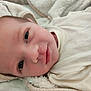 Théo participe au concours pour gagner de l'argent avec cette photo : baby, blanket, child, clothing, cozy, cute, eyes, face, happy, head, indoors, infant, lying_down, newborn, person, portrait, skin, smiling, soft, young