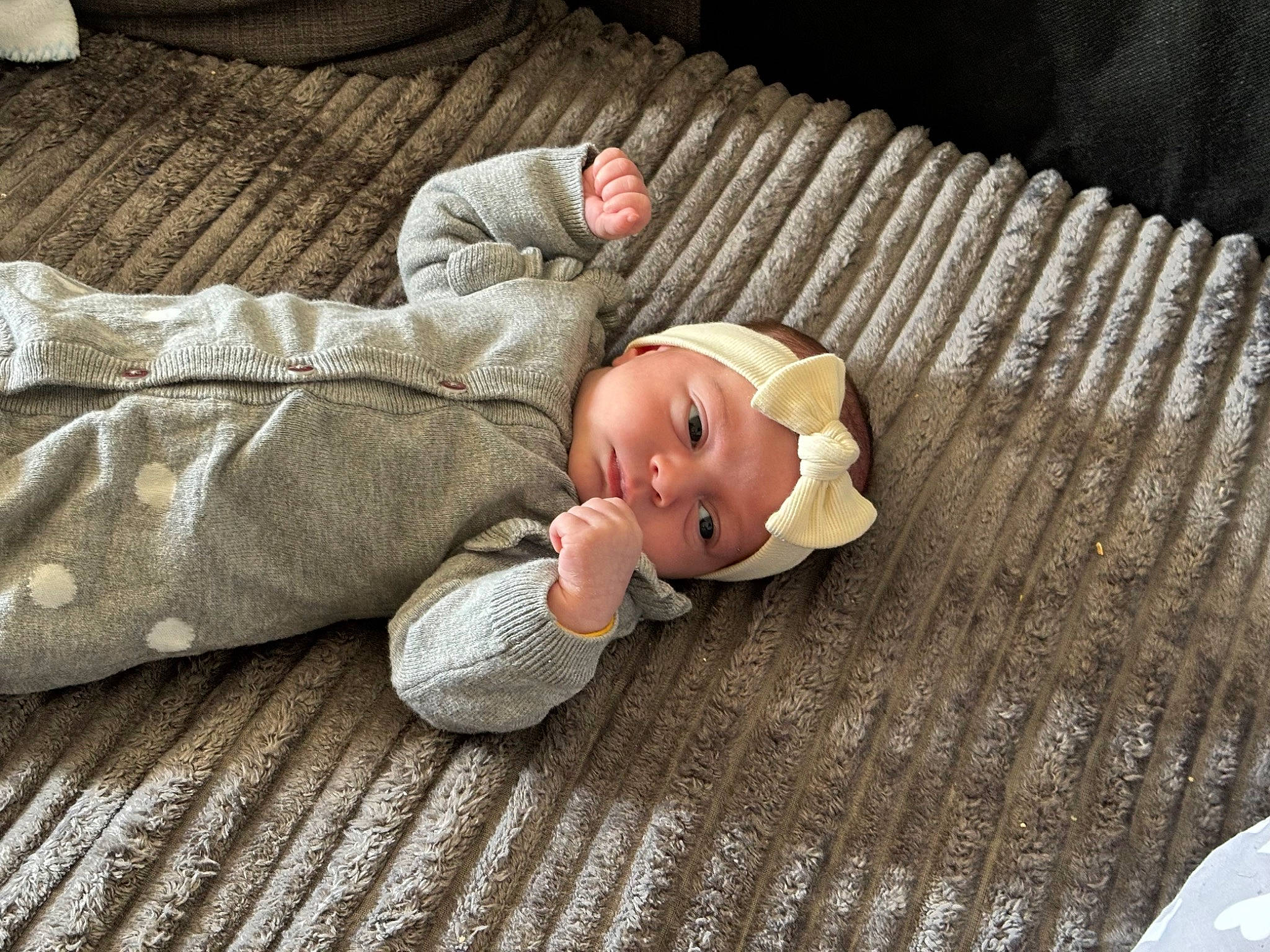 Katalëya participe au concours pour gagner de l'argent avec cette photo : baby, baby_products, baby_toddler_clothing, brown, cheek, child, comfort, doll, facial_expression, flooring, hardwood, head, headwear, linens, person, sitting, skin, sleeve, toddler, toy