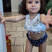 Isabel Escobedo joined the competition — help win amazing prizes! toddler, child, indoor, tile_floor, clothing, nautical_pattern, polka_dots, reaching, blurred, person, footwear, pink_shoes, hair_bow, wall, household_items, young_child, cute, casual, portrait, motion