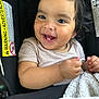 baby, child, smiling, face, eyes, teeth, pacifier, blanket, car_seat, clothing, infant, cute, happy, indoors, person, young_child, hair, skin, seatbelt, closeup