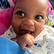 Eyrane participe au concours pour gagner de l'argent avec cette photo : baby, background, blue, child, clothing, cushion, cute, eyes, face, hand, happy, indoors, infant, onesie, pattern, pink, portrait, skin, smile, space