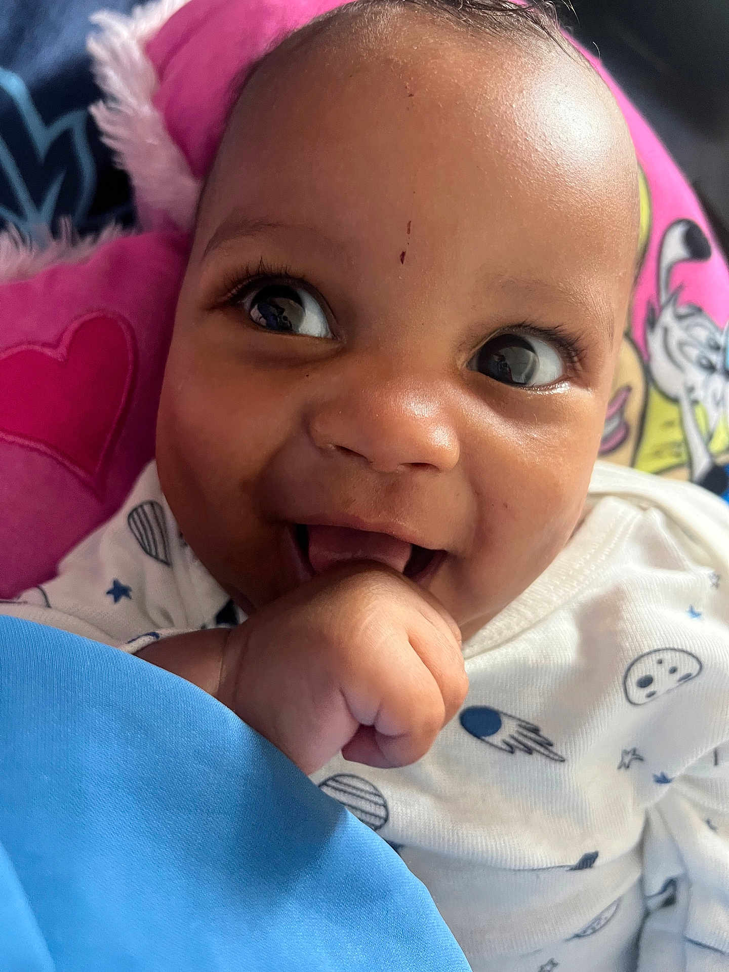 Eyrane participe au concours pour gagner de l'argent avec cette photo : baby, background, blue, child, clothing, cushion, cute, eyes, face, hand, happy, indoors, infant, onesie, pattern, pink, portrait, skin, smile, space