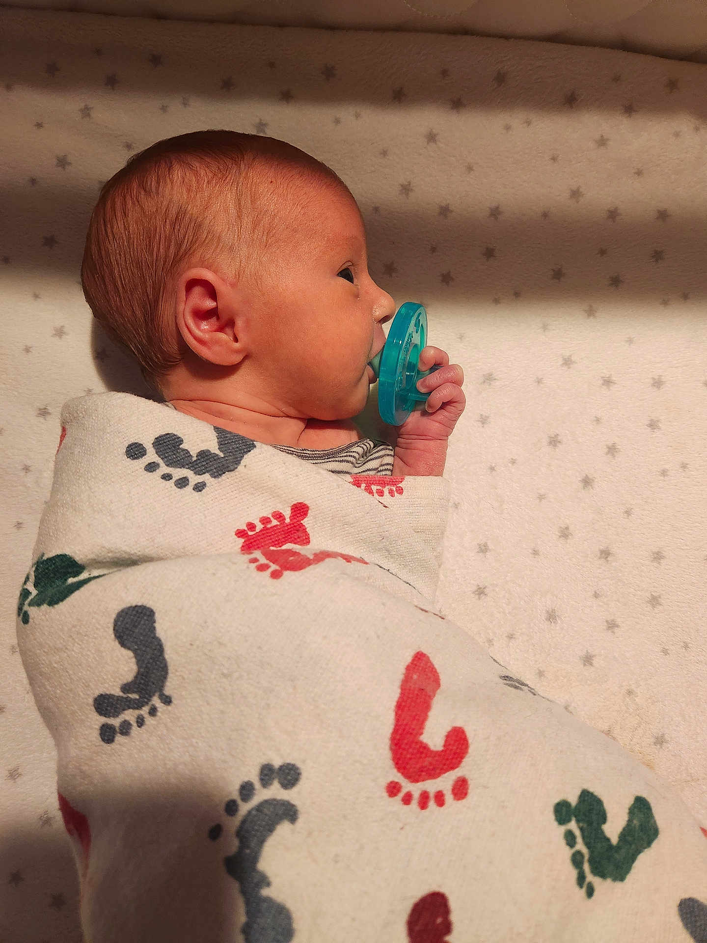 Spencer joined the competition — help win amazing prizes! newborn, baby, pacifier, blanket, footprint_pattern, swaddled, infant, side_profile, sleeping, soft_lighting, cozy, star_pattern, bed, cute, small_hand, wrapped, peaceful, human, child, indoors