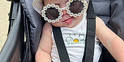 Sophia joined the competition — help win amazing prizes! baby, stroller, sunglasses, hat, flower_pattern, child, summer, outdoor, cute, fashion, seatbelt, infant, sun_protection, casual, green, white, yellow, smiling, baby_clothes, accessory