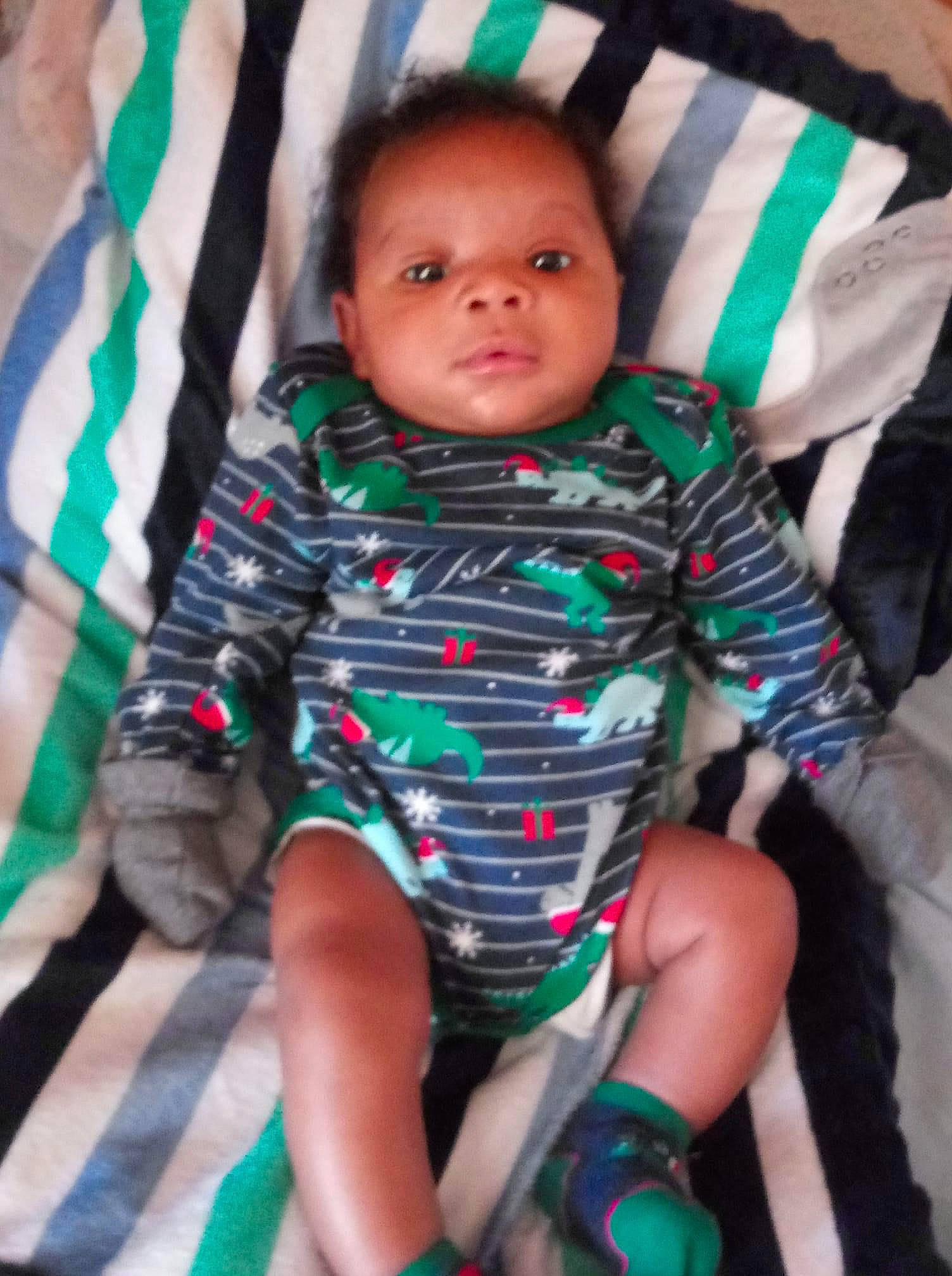 Dakari is registered to the contest to win money with this photo: baby, baby_toddler_clothing, chair, cheek, comfort, eye, finger, fun, green, happy, head, iris, lap, leg, organ, person, pink, skin, sleeve, thigh