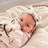 baby, infant, blanket, headband, flower_pattern, blue_eyes, cozy, soft_texture, smiling, cute, portrait, wrapped, child, toddler, indoor, warm, comfort, closeup, happy, resting