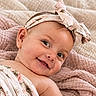 baby, smiling, headband, bow, blanket, floral, cute, infant, skin, portrait, child, happy, texture, fabric, soft, lying_down, closeup, indoors, toddler, wrapped