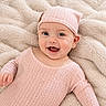 baby, infant, smile, pink_clothing, hat, blanket, cozy, happy, portrait, child, cute, soft_texture, lying_down, knitwear, face, cheerful, indoor, closeup, person, toddler