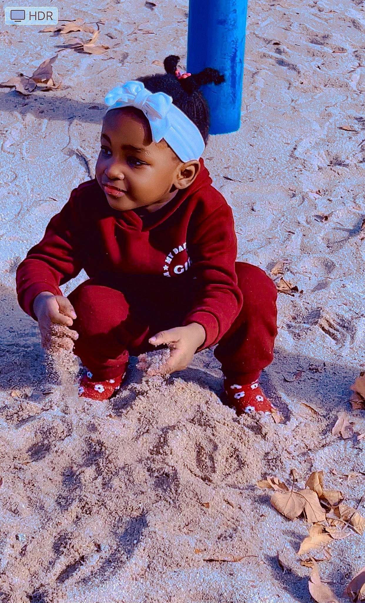 Shantal is registered to the contest to win money with this photo: baby, baby_toddler_clothing, cap, carmine, child, electric_blue, freezing, fun, hat, headwear, landscape, leisure, people_in_nature, person, play, playing_in_the_snow, recreation, sand, sitting, soil