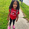 child, girl, smiling, portrait, outdoors, sidewalk, grass, neighborhood, backpack, red_shirt, pink_shoes, curly_hair, standing, sunny, family, children, street, house, vehicle, fashion