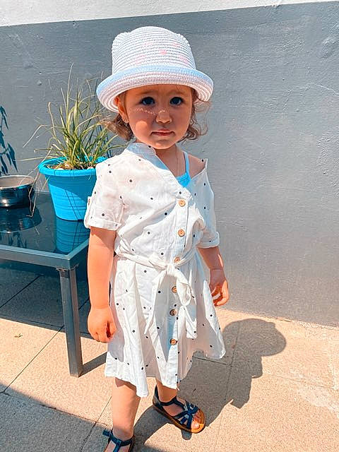 Lou a rejoint le concours — aidez-le/la à gagner de superbes lots ! baby, baby_toddler_clothing, child, day_dress, dress, electric_blue, face, flowerpot, hat, headwear, houseplant, joint, pattern, person, plant, sandal, sleeve, street_fashion, sun_hat, sunglasses