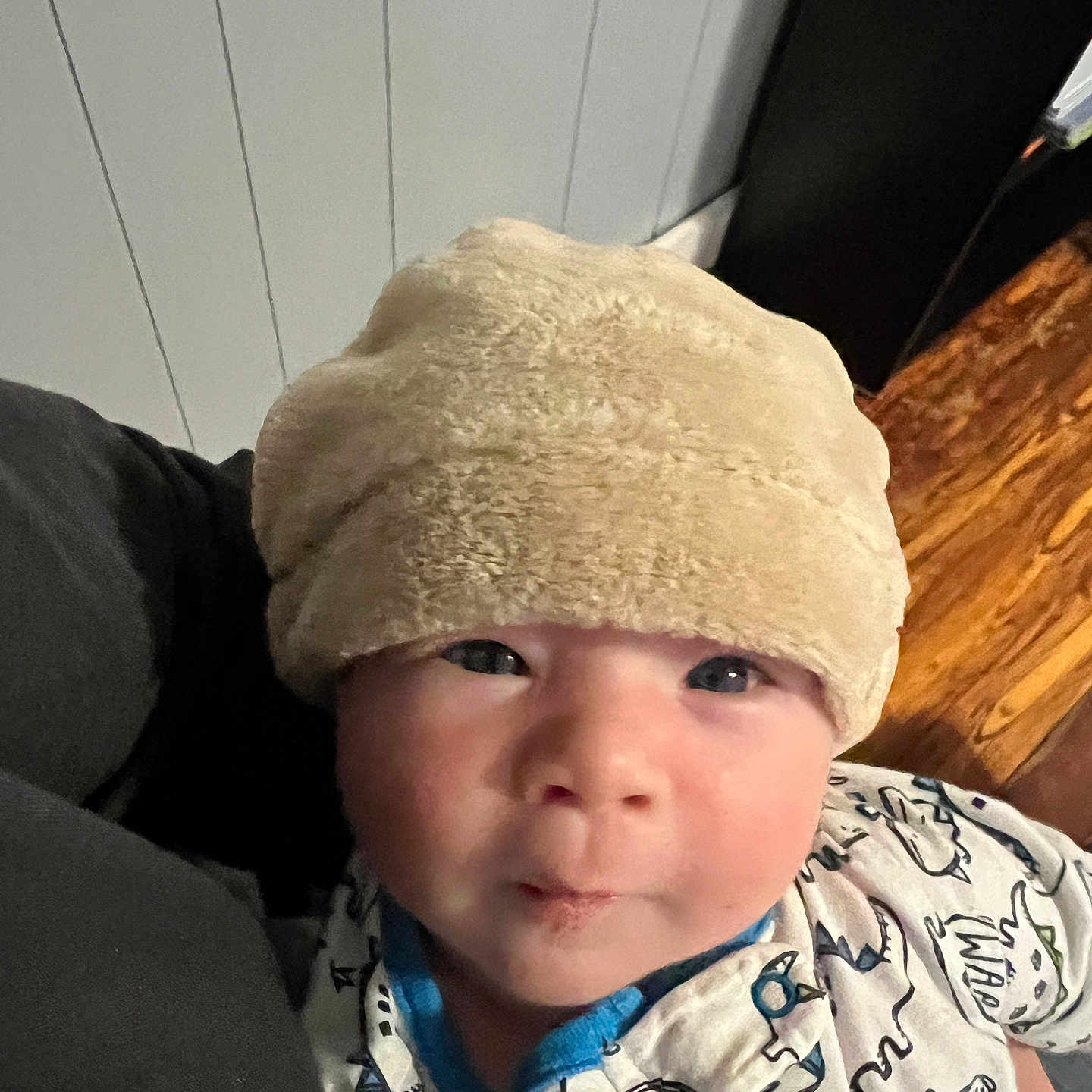 Waylon is registered to the contest to win money with this photo: baby, baseballcap, beanie, bonnet, cap, clothing, coat, couch, face, fleece, furniture, hat, head, hood, jacket, pants, person, photography, portrait, wood