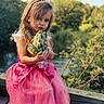 Aaliyah is registered to the contest to win money with this photo: child, girl, princess_dress, pink_dress, toy, frog_toy, pout, long_hair, outdoor, nature, greenery, wooden_ledge, portrait, cute, playful, summer, daylight, smile, happy, person