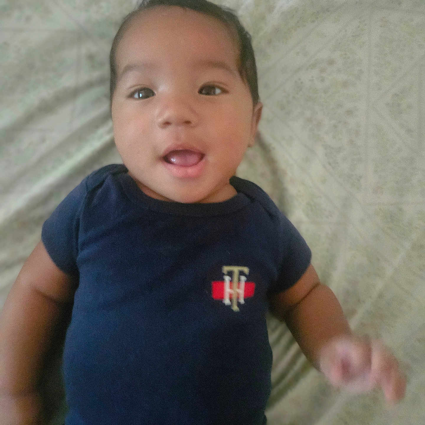 Sejong is registered to the contest to win money with this photo: baby, bed, casual, child, clothing, cute, expression, face, hair, hand, indoors, infant, lying_down, onesie, pattern, person, portrait, skin, smiling, young_child