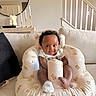 baby, bear_pattern, candles, child, couch, cozy, curly_hair, cute, decor, happy, home_interior, infant, inflatable_chair, living_room, mirror, seated, smile, socks, stairs, white_clothing