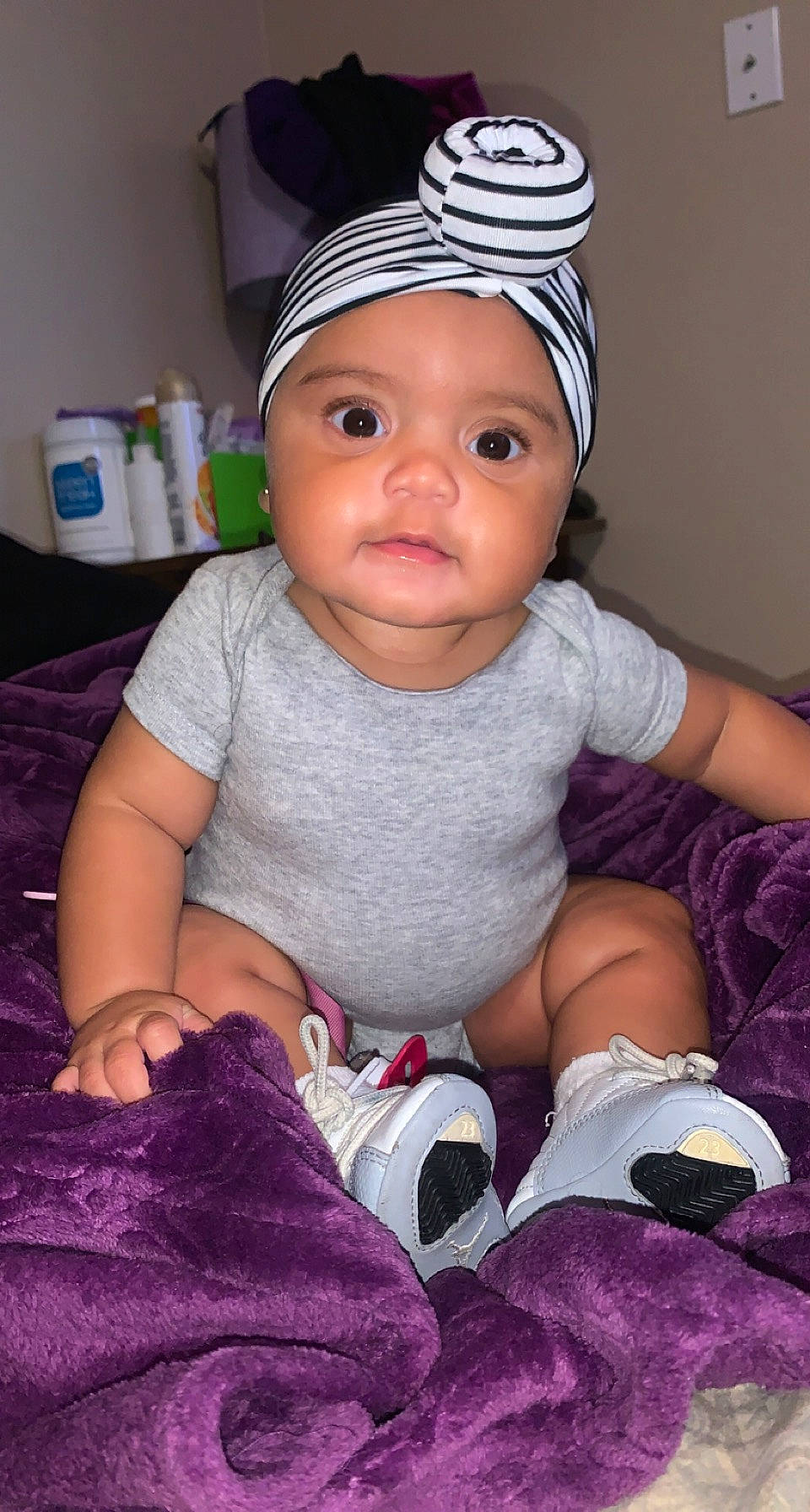 Naveah is registered to the contest to win money with this photo: baby, baby_toddler_clothing, cap, cheek, child, comfort, eye, face, finger, happy, headgear, headwear, lip, magenta, person, pink, purple, sleeve, textile, toddler
