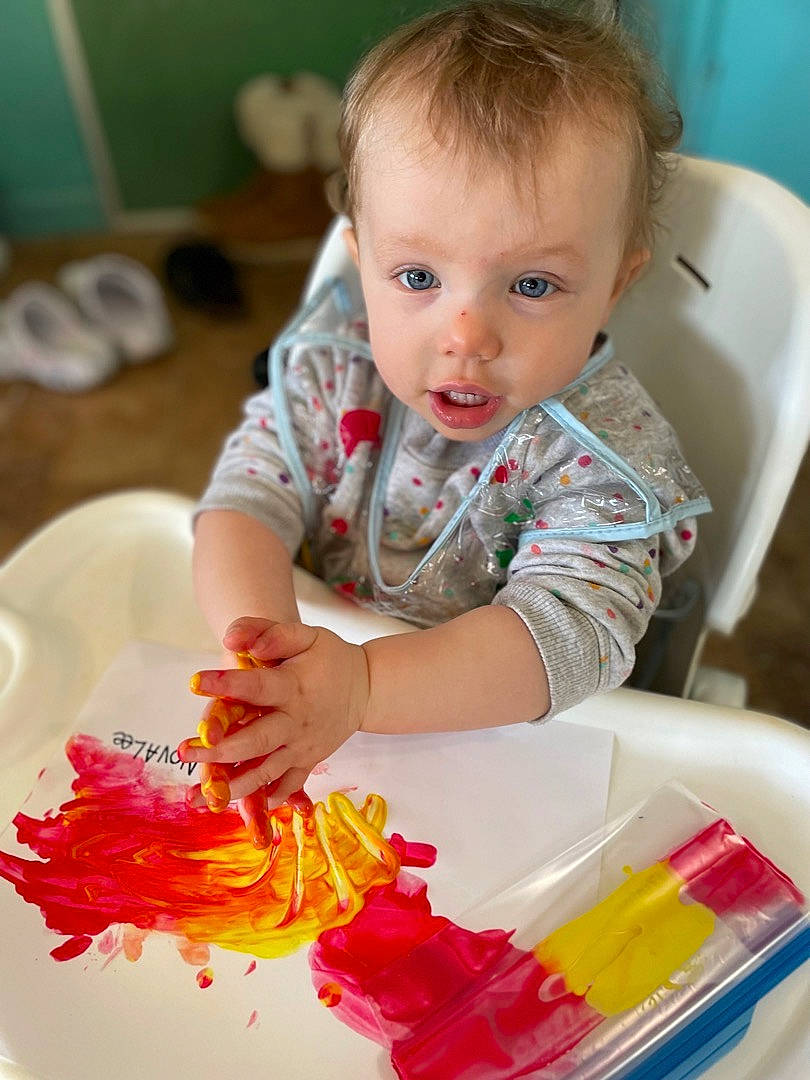 Novalee is registered to the contest to win money with this photo: baby, baby_toddler_clothing, cheek, child, comfort_food, dress, event, flooring, fun, person, plastic, play, room, sitting, sleeve, t_shirt, toddler