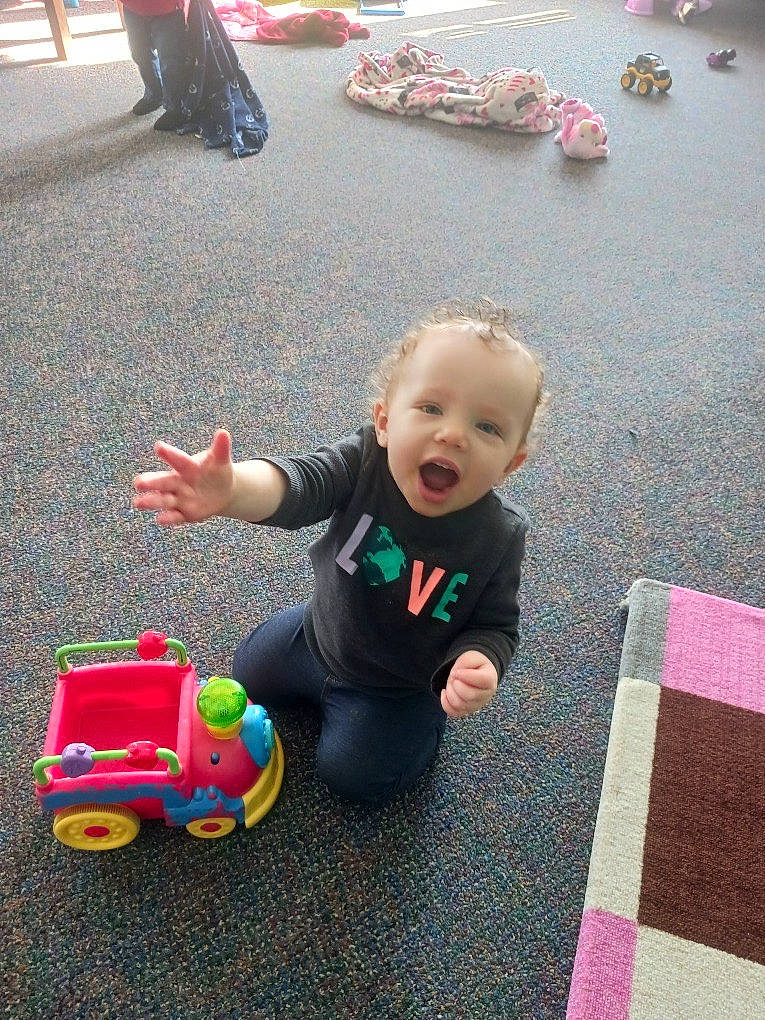 Novalee joined the competition — help win amazing prizes! asphalt, baby, baby_products, baby_toddler_clothing, child, city, flooring, fun, grass, leisure, person, photograph, play, recreation, riding_toy, road_surface, sitting, snapshot, toddler, toy