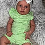 baby, infant, child, green_outfit, headband, white_bow, red_eye, fluffy_blanket, soft_texture, sitting, indoors, cute, portrait, hands, legs, skin, face, expression, clothing, comfort