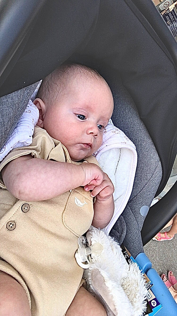 Tony participe au concours pour gagner de l'argent avec cette photo : baby, baby_products, baby_toddler_clothing, chair, cheek, child, comfort, facial_expression, finger, gesture, happy, iris, linens, mammal, person, product, skin, sleeve, textile, toddler