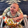 baby, walker, smiling, toy, colorful, infant, happy, patterned_rug, playful, clothing, person, cute, indoors, seat, bright, child, expression, face, sitting, cheerful