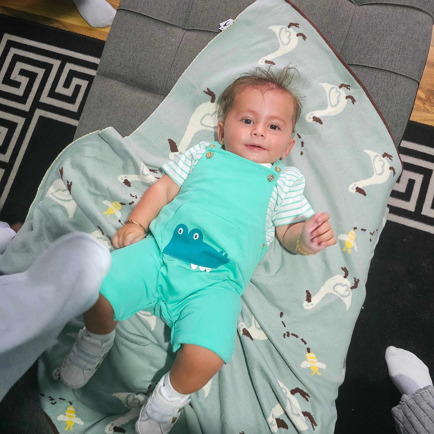 Selym joined the competition — help win amazing prizes! baby, blanket, child, clothing, crocodile_print, cute, feet, floor, hair, happy, indoor, ottoman, pattern, person, relaxed, smile, socks, striped_shirt, toy, wooden_floor