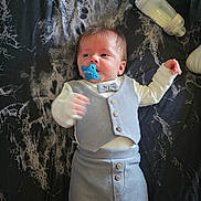Selym joined the competition — help win amazing prizes! baby, pacifier, bottle, clothing, bow_tie, blanket, infant, cute, lying_down, blue, grey, marble_pattern, newborn, baby_outfit, small_hands, bed, soft_lighting, indoors, child, face